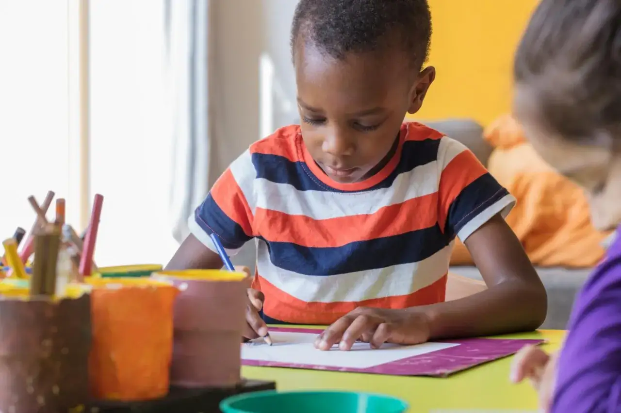 Konzentrierter Junge malt im Kindergarten. Kreativität und **Motivation bei Kindern im Kindergarten** fördern.