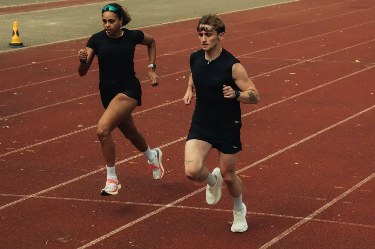 Zwei Läufer auf einer Tartanbahn. Sie trainieren, um sich von ihrem letzten Halbmarathon zu erholen. Wie lange Pause nach Halbmarathon?