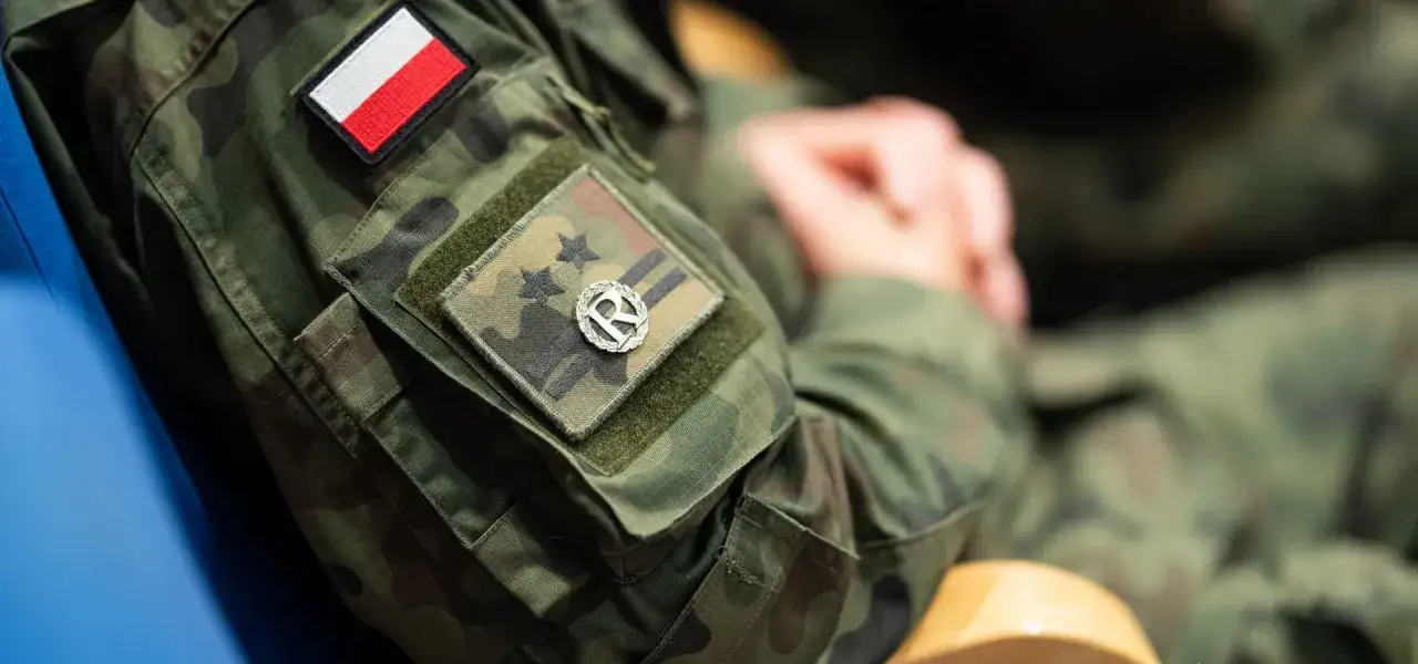 Żołnierze rezerwy dumnie noszą mundury z polską flagą i naszywką.
