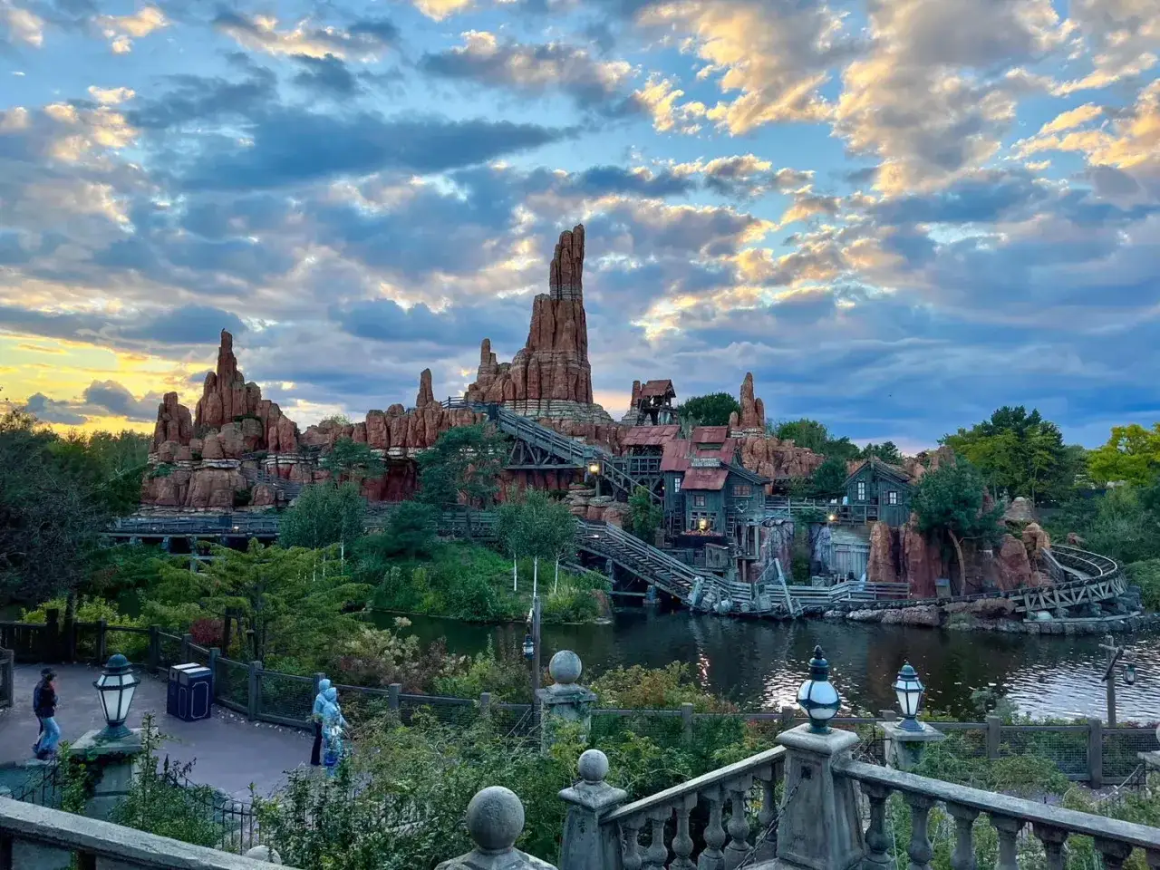 Spektakul&auml;re Disneyland-Attraktionen: Big Thunder Mountain mit dramatischem Himmel und Wasser.