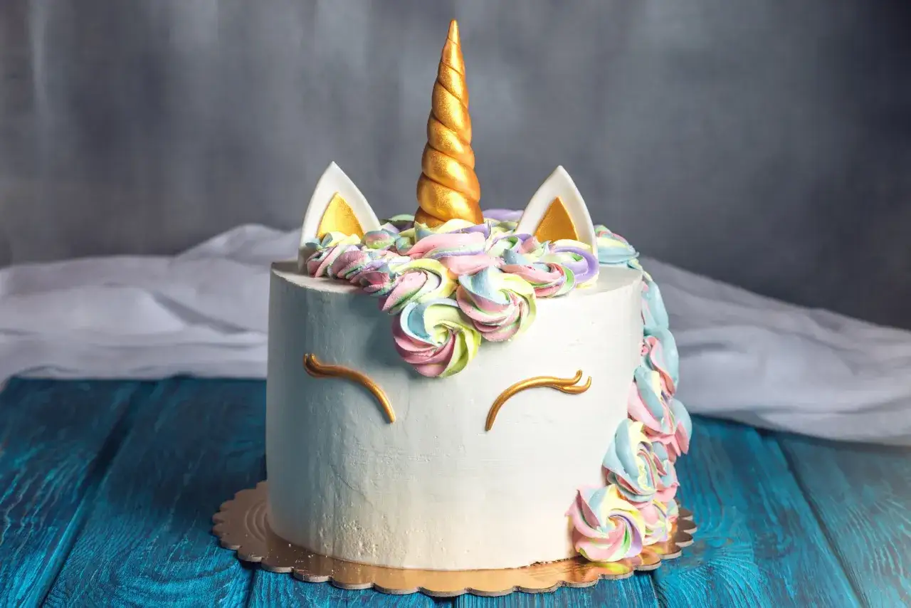 En magisk hemmagjord tårta barn skulle älska, med enhörningshorn och färgglad frosting.