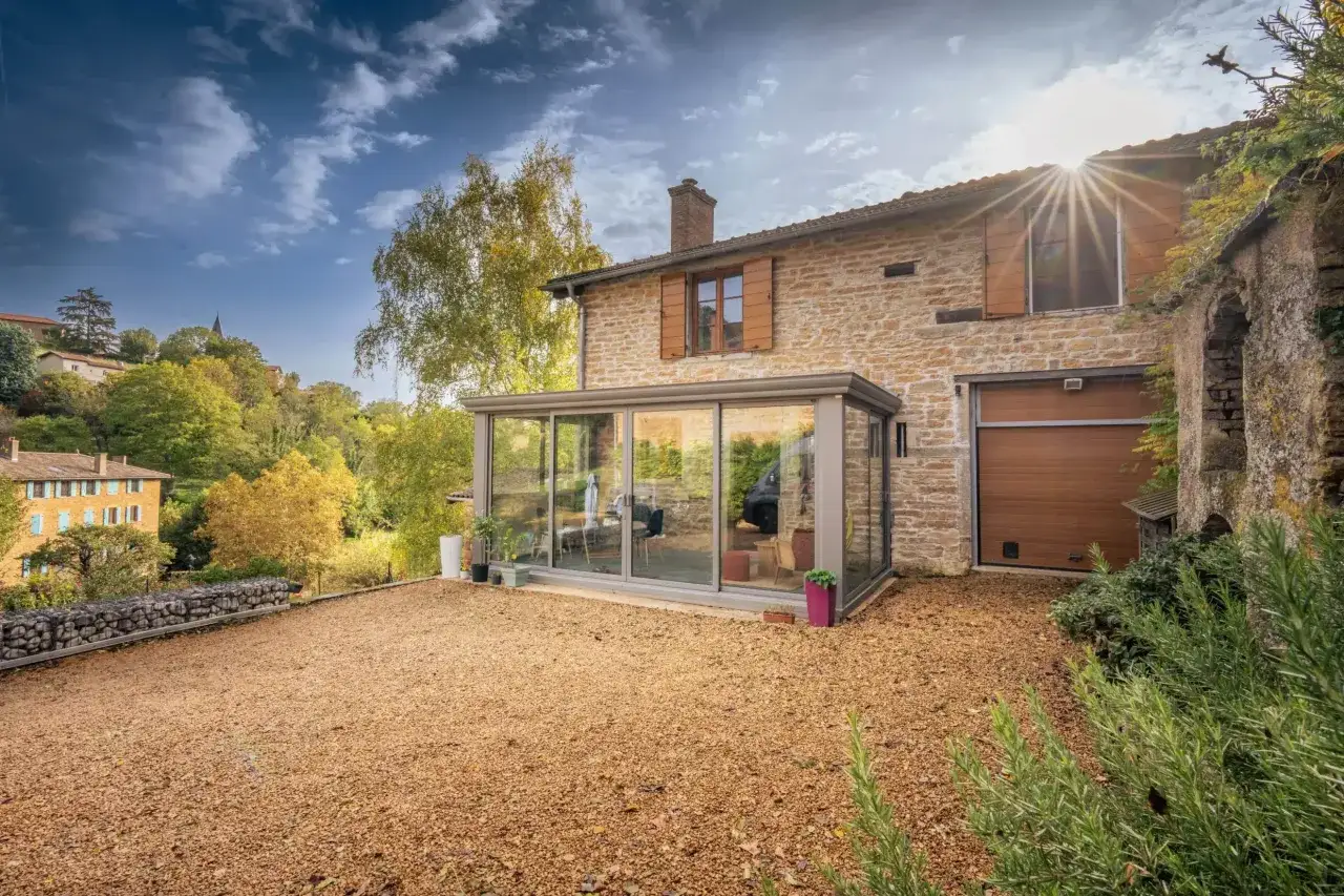 Maison en pierre avec v&eacute;randa moderne. Id&eacute;al pour construire une v&eacute;randa soi m&ecirc;me et profiter du paysage.
