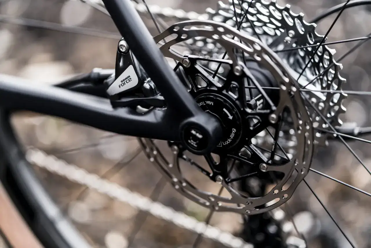 Close-up of a bicycle's rear wheel, showing the SRAM Force brake caliper and the Hope RX4 rotor. The cassette is visible in the background.