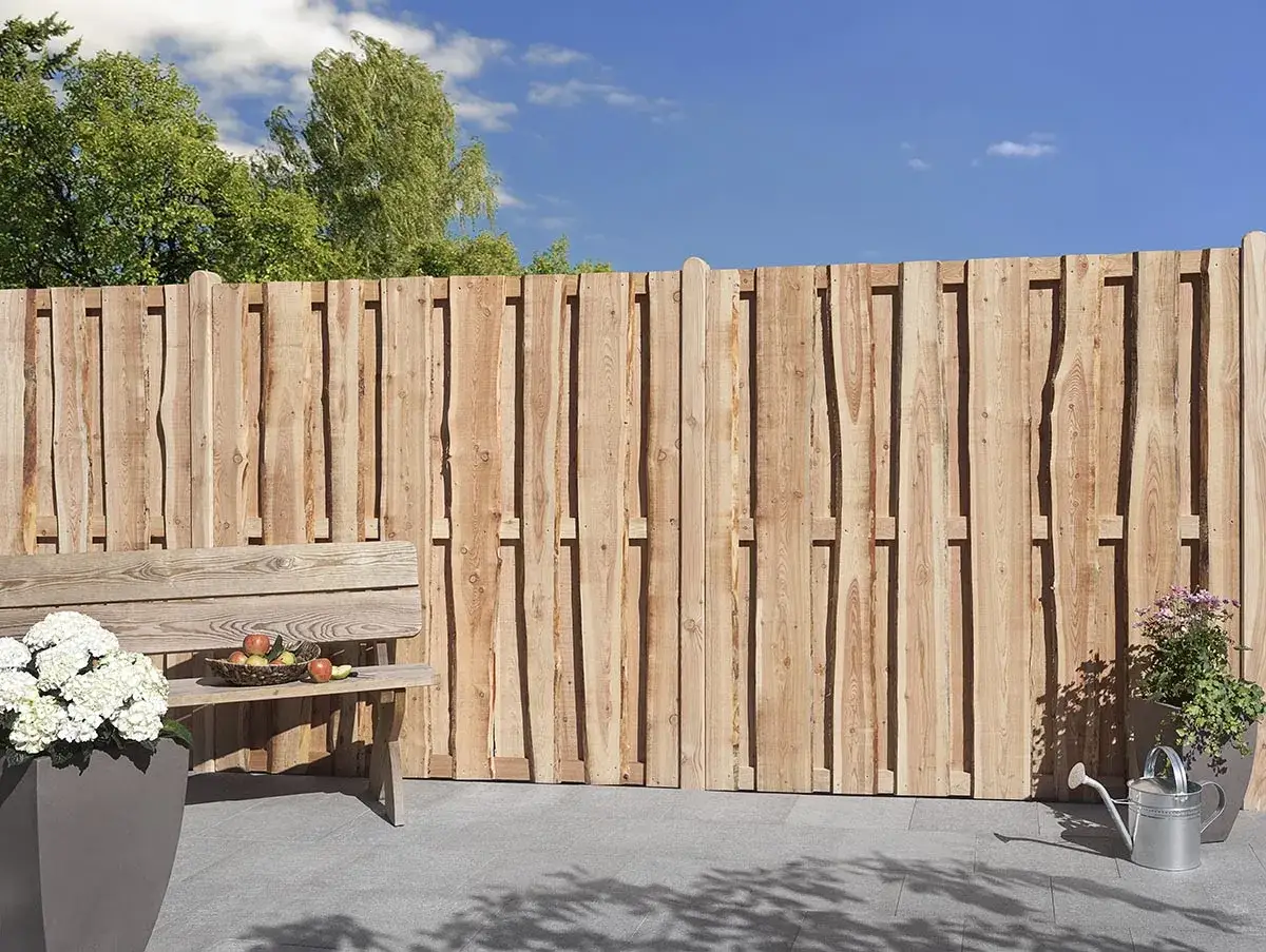 Nat&uuml;rliche Holzzaun-Sichtschutz-Ideen f&uuml;r Ihren Garten. Eine Holzbank l&auml;dt zum Verweilen ein.