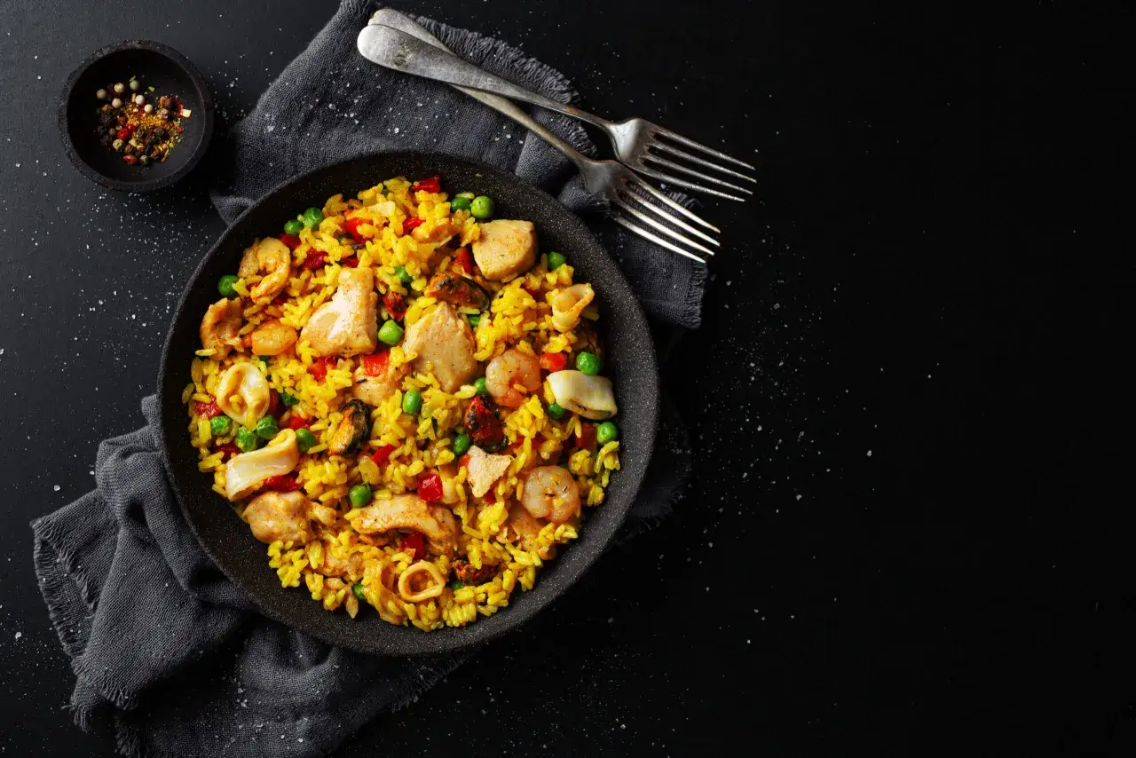 Pyszna paella z kurczakiem, krewetkami i małżami. Idealny przepis na obiad.