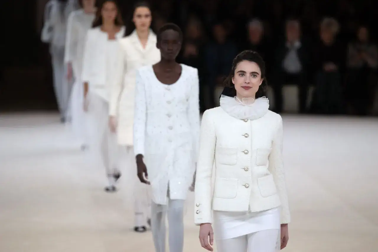 Sfilata di moda con modelli che indossano eleganti coco chanel abiti iconici bianchi, un tributo alla raffinatezza.