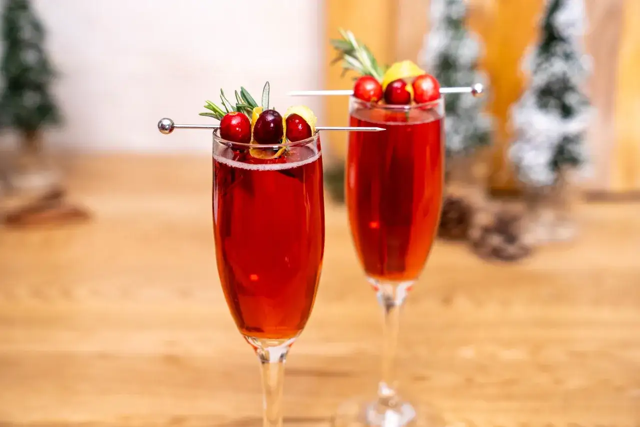 Tv&aring; glas med r&ouml;d drink, garnerade med tranb&auml;r, rosmarin och citronskal. Perfekt drink till ny&aring;r!