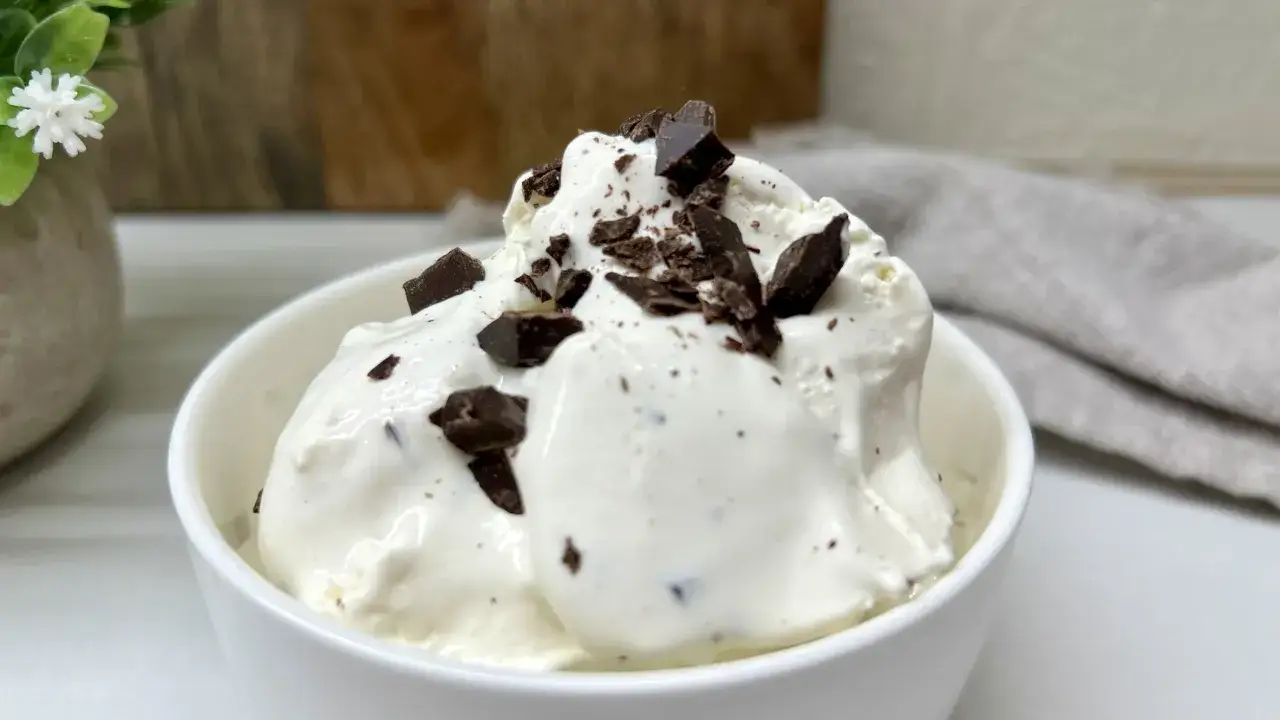 Pyszne lody straciatella co to? Kremowe lody waniliowe z kawałkami gorzkiej czekolady w białej miseczce.
