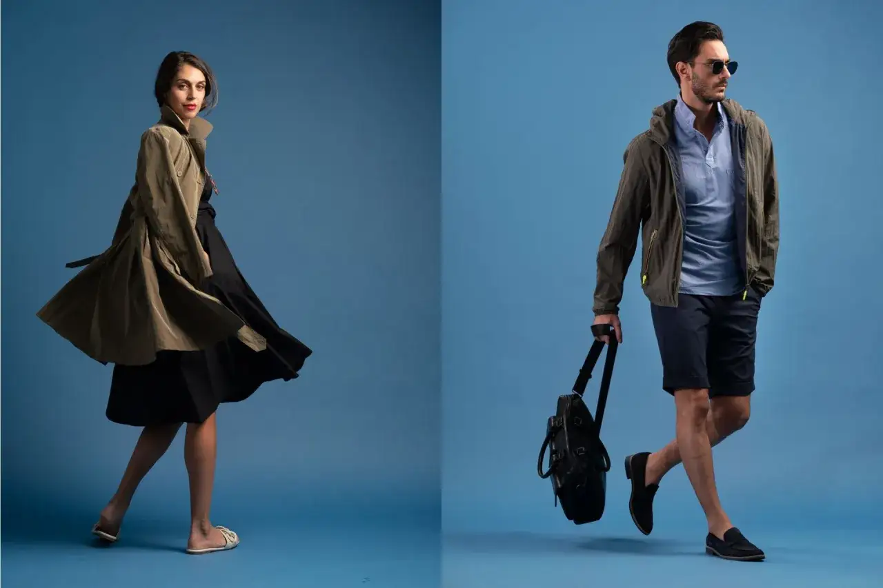 Donna con trench e abito nero, uomo con giacca, polo e pantaloncini. Entrambi con un look casual, cosa significa regular fit: vestibilità comoda ma definita.
