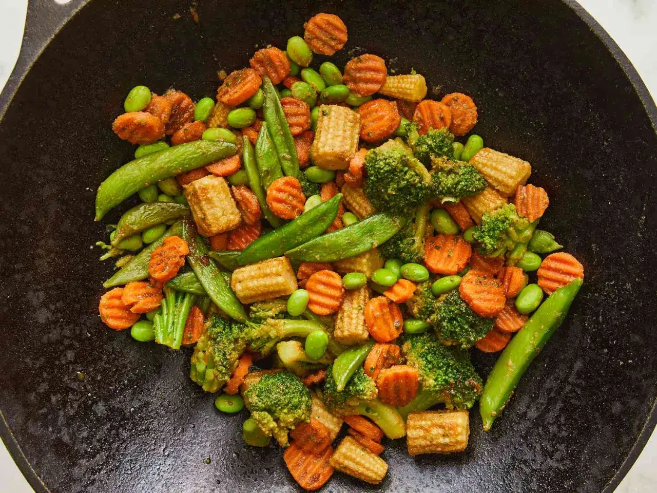 Pyszny kurczak po chińsku z mieszanką chińską: brokuły, marchewka, edamame i groszek cukrowy w woku.