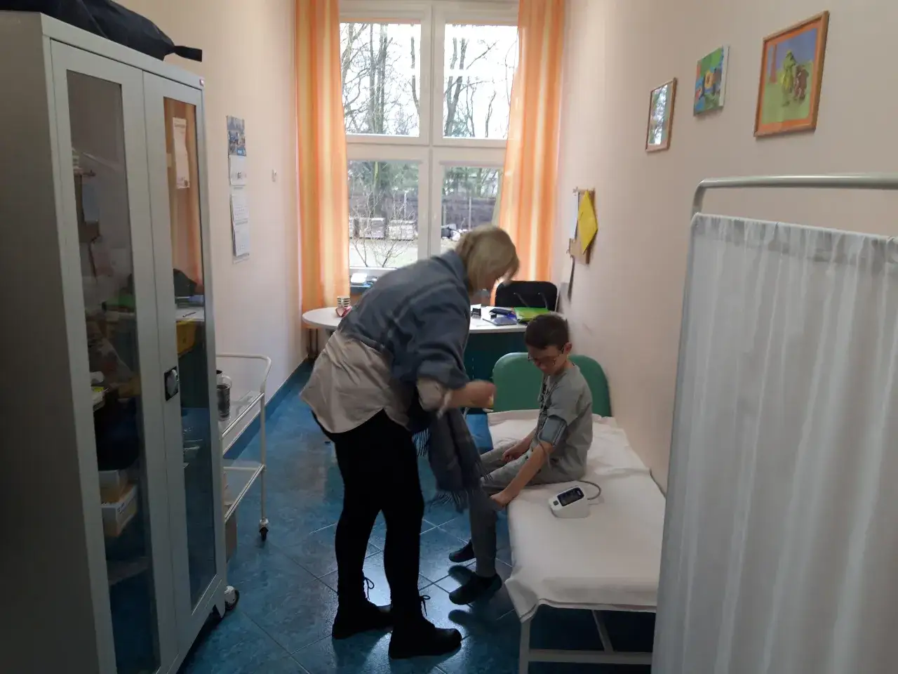 Pielęgniarka szkolna mierzy ciśnienie chłopcu. Zastanawiasz się, ile zarabia pielęgniarka szkolna?