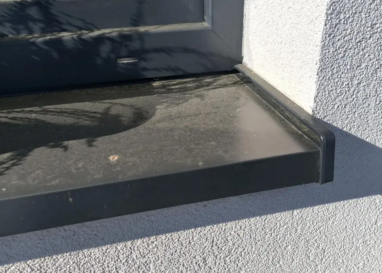 Zabrudzony, ciemny parapet zewnętrzny pod oknem. Zastanawiasz się, czym czyścić parapety zewnętrzne, by wyglądały jak nowe?