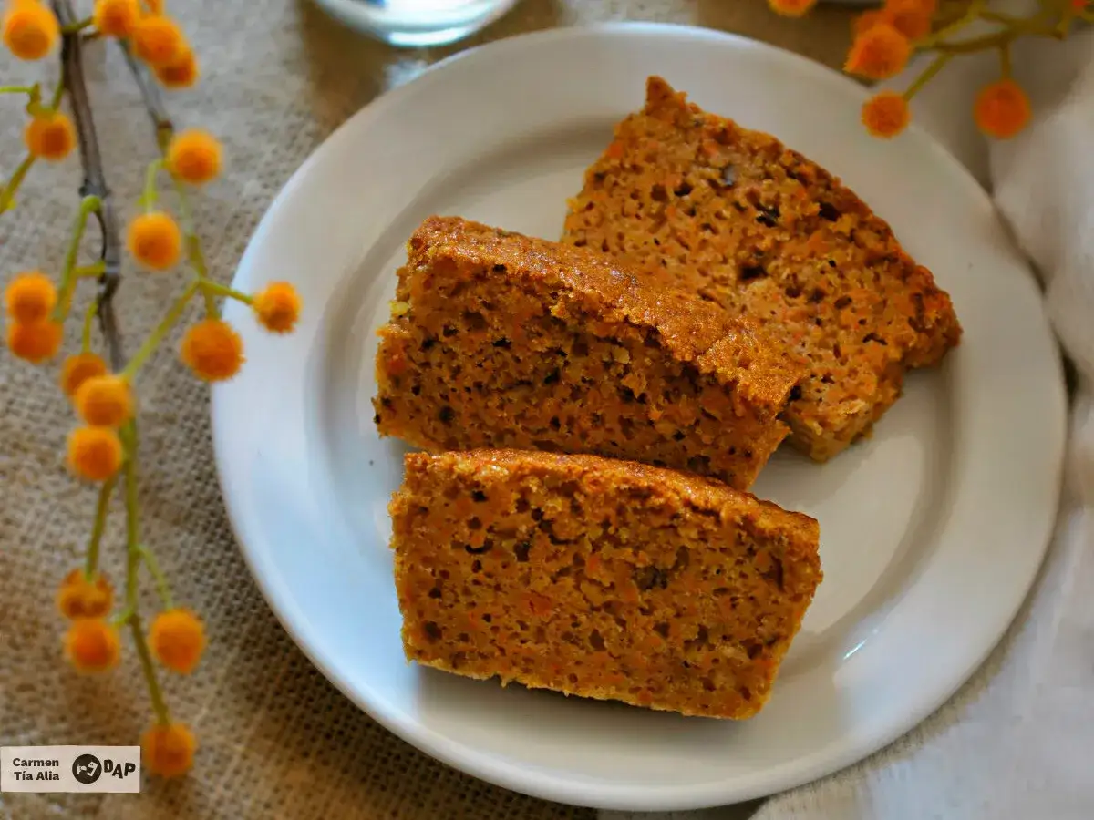 Rebanadas de bizcocho de zanahoria casero, con trocitos de zanahoria visibles, servidas en un plato blanco.