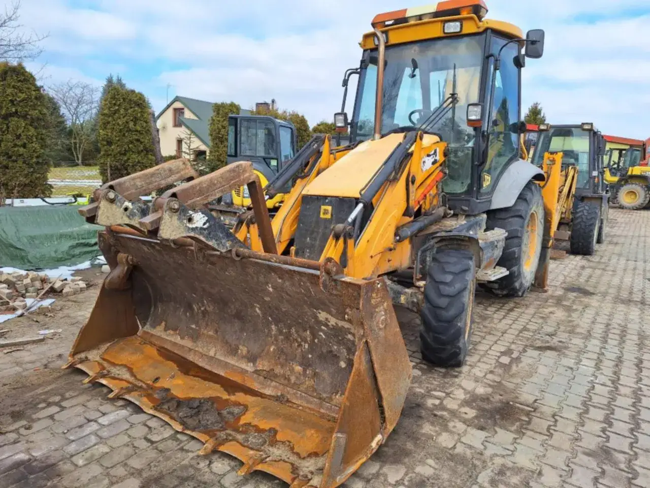 Nowa koparko ładowarka JCB gotowa do pracy. Potężna maszyna z szeroką łyżką i solidnym ramieniem.