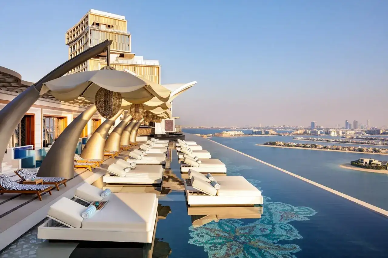 Luksusowy basen infinity z leżakami i widokiem na Dubaj. Idealne miejsce na wakacje, o którym przeczytasz w biuro podróży index opinie.