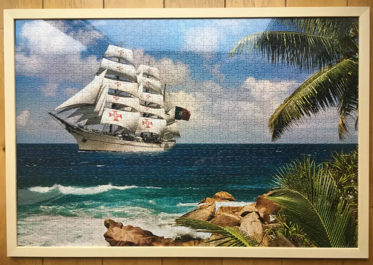 Ramka z puzzlami: żaglowiec na tle nieba i morza, z palmami. Idealne, by pokazać, jak powiesić puzzle na ścianie.