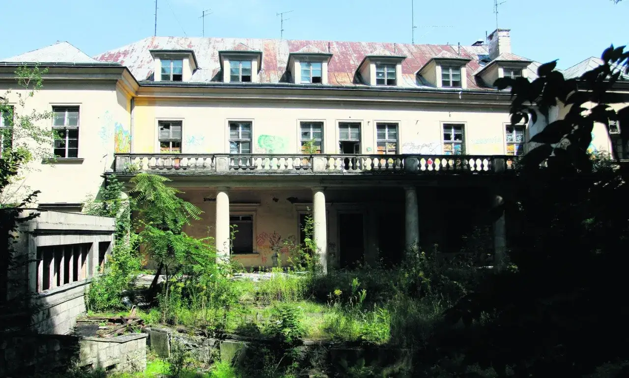Zaniedbany pałac Tarnowskich w Krakowie, zniszczony dach, okna i elewacja pokryta graffiti.