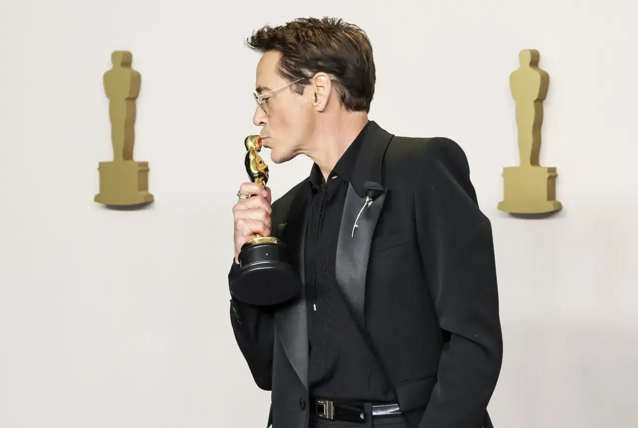 L'attore di Oppenheimer, Robert Downey Jr., bacia il suo Oscar.
