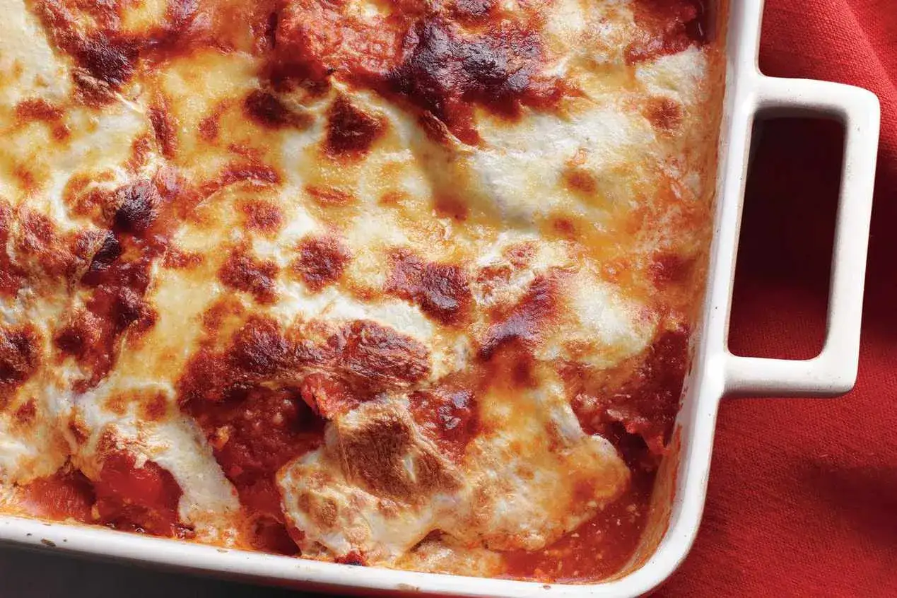 Ein goldbraun überbackenes Melanzane alla Parmigiana Originalrezept in einer weißen Auflaufform.