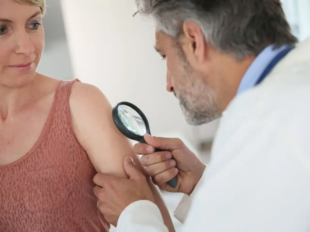 Dermatolog bada pieprzyki u pacjentki. To pokazuje, ile jest ważne skierowanie do dermatologa, by zadbać o zdrowie skóry.