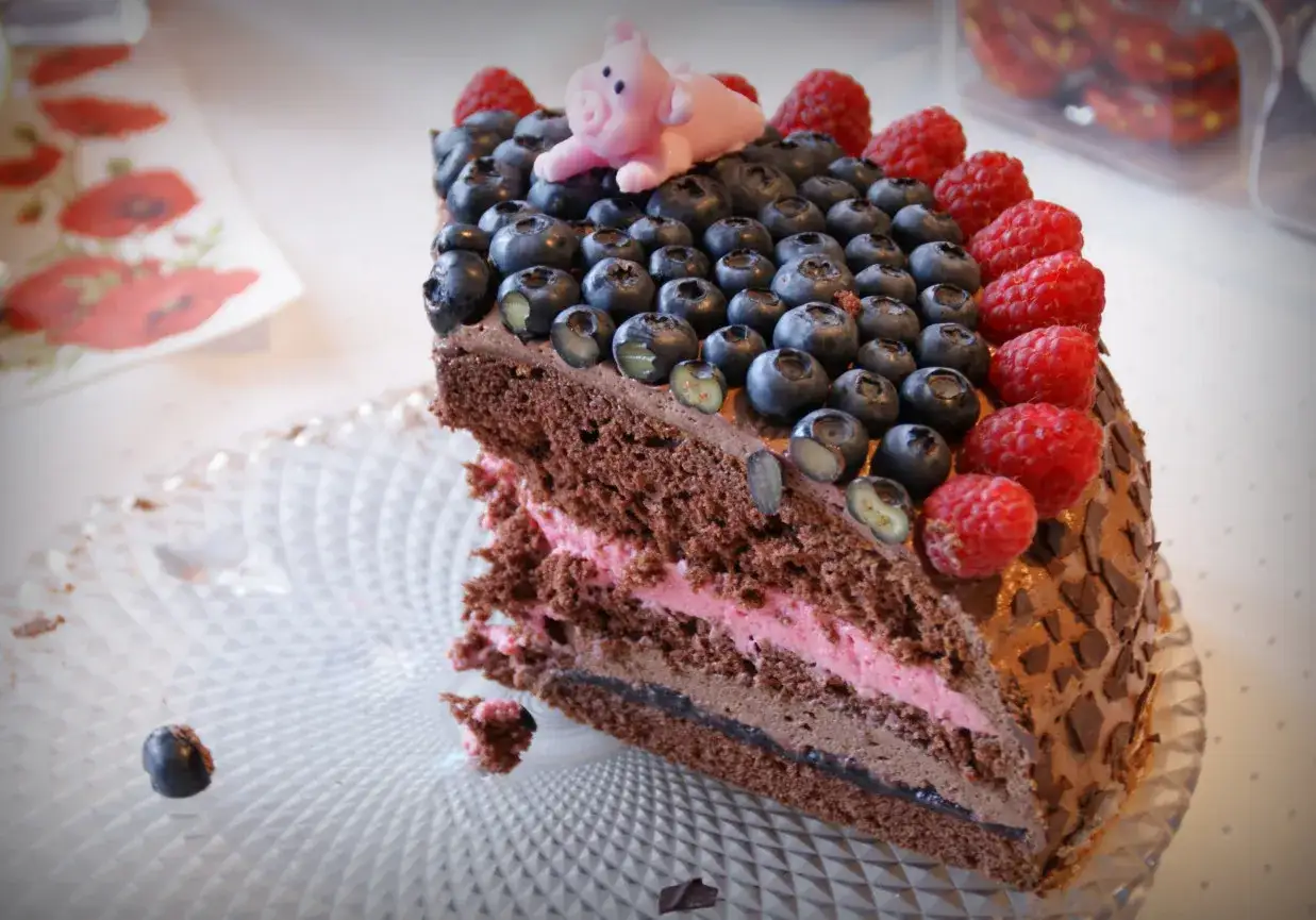 Obłędny tort czekoladowy z mascarpone i owocami: jagody, maliny i urocza świnka na wierzchu. Prawdziwa uczta dla zmysłów!