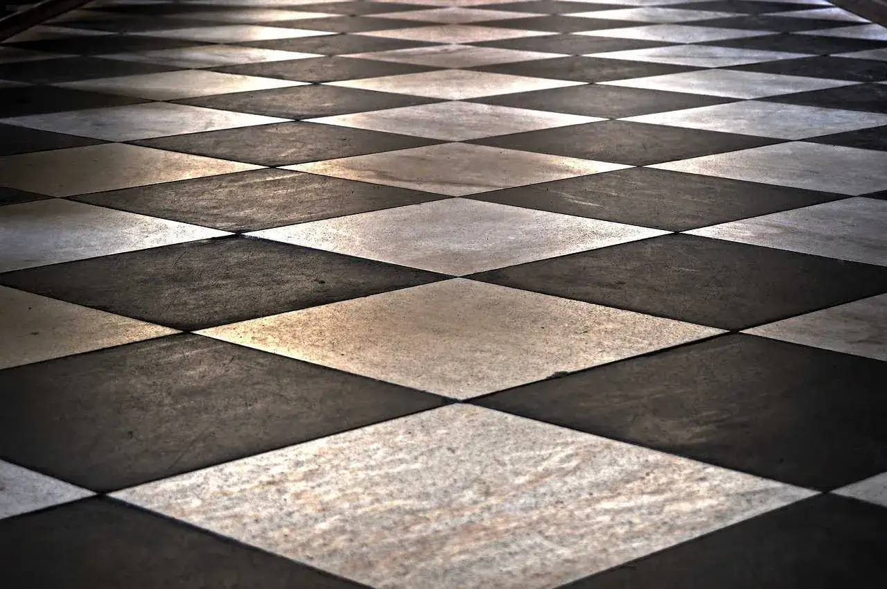 Pavimento a scacchi con posa piastrelle a 45 gradi, creando un effetto visivo di profondità e movimento.