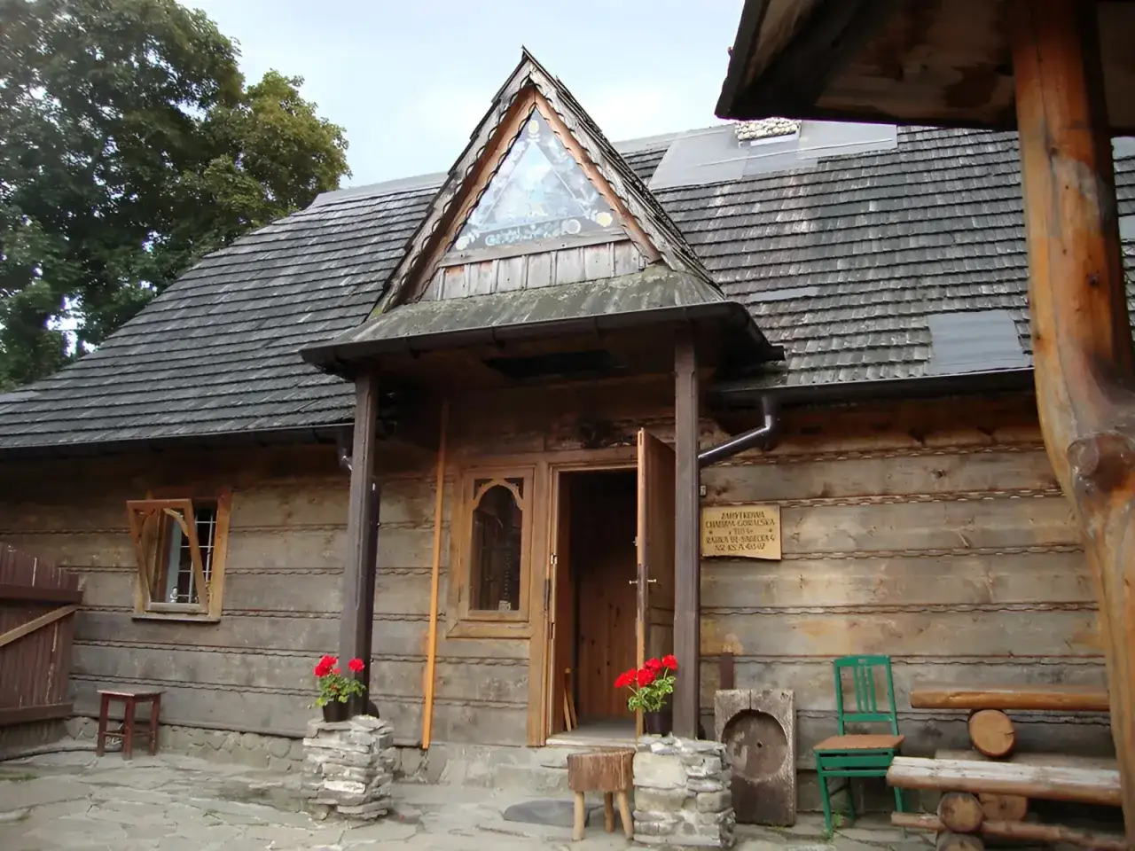 Drewniany budynek muzeum g&oacute;rali i zb&oacute;jnik&oacute;w z charakterystycznym tr&oacute;jkątnym okienkiem nad wejściem.