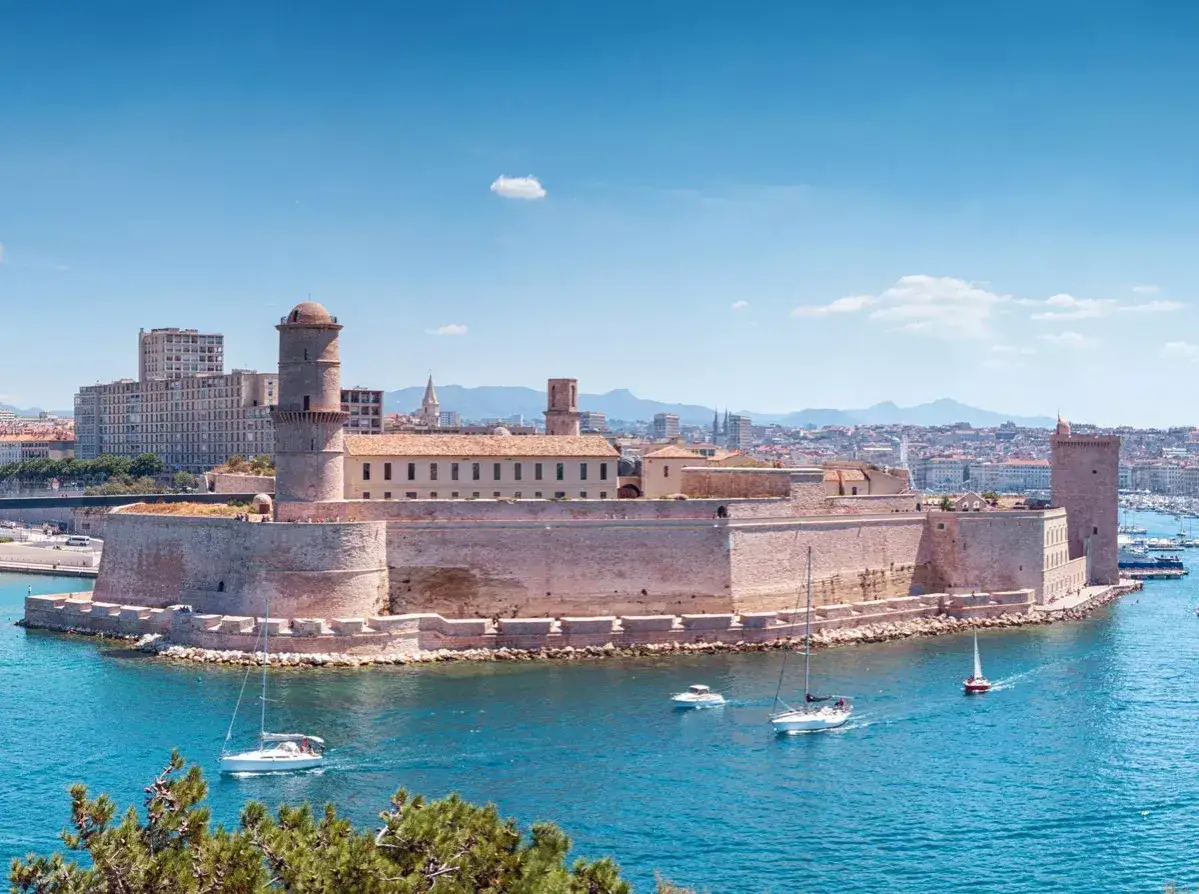 Fort Saint-Jean, un luogo imperdibile da vedere a Marsiglia vicino al porto, con barche a vela nel blu intenso del Mediterraneo.