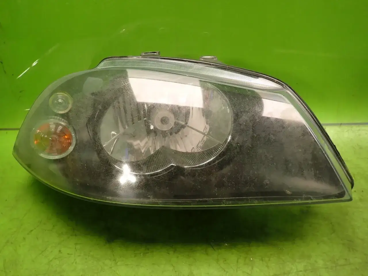 Reflektor przedni do Seat Ibiza 3, z pomarańczową żarówką pozycyjną i miejscem na żarówkę główną.