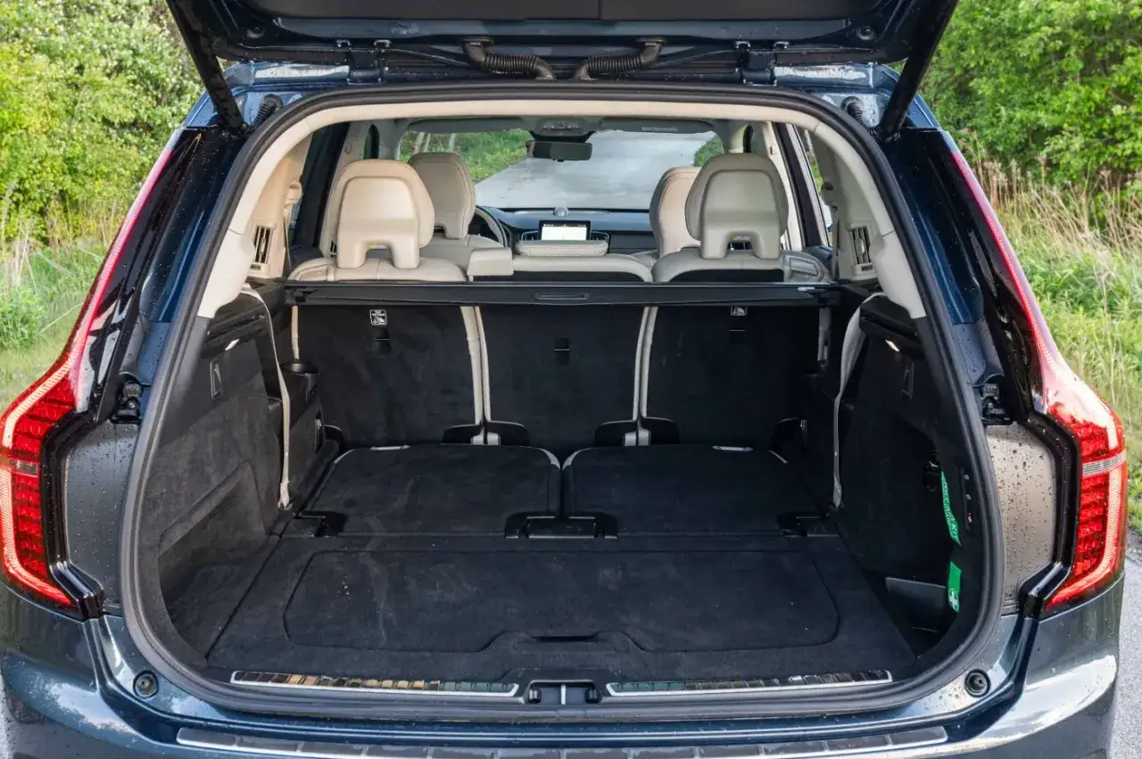 Wnętrze Volvo XC90 z otwartym bagażnikiem. Widok na rozłożone siedzenia i przestronną przestrzeń bagażową. Sprawdź aktualną volvo xc90 cena.