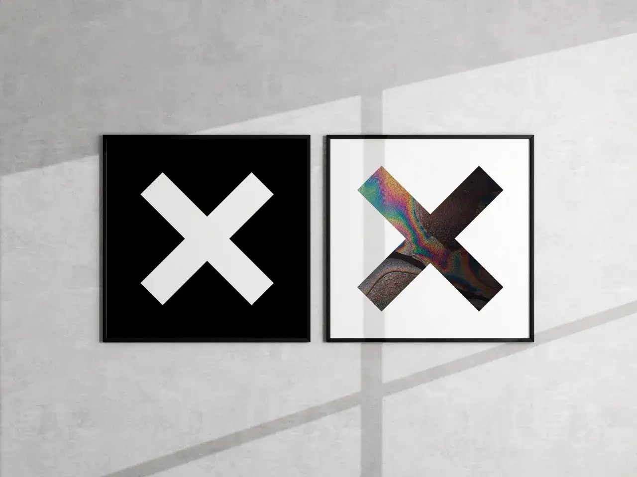 Deux cadres sur un mur de b&eacute;ton : l'un avec un X blanc sur fond noir, l'autre avec un X aux couleurs iris&eacute;es. Une ambiance minimaliste rappelant les albums de The xx.