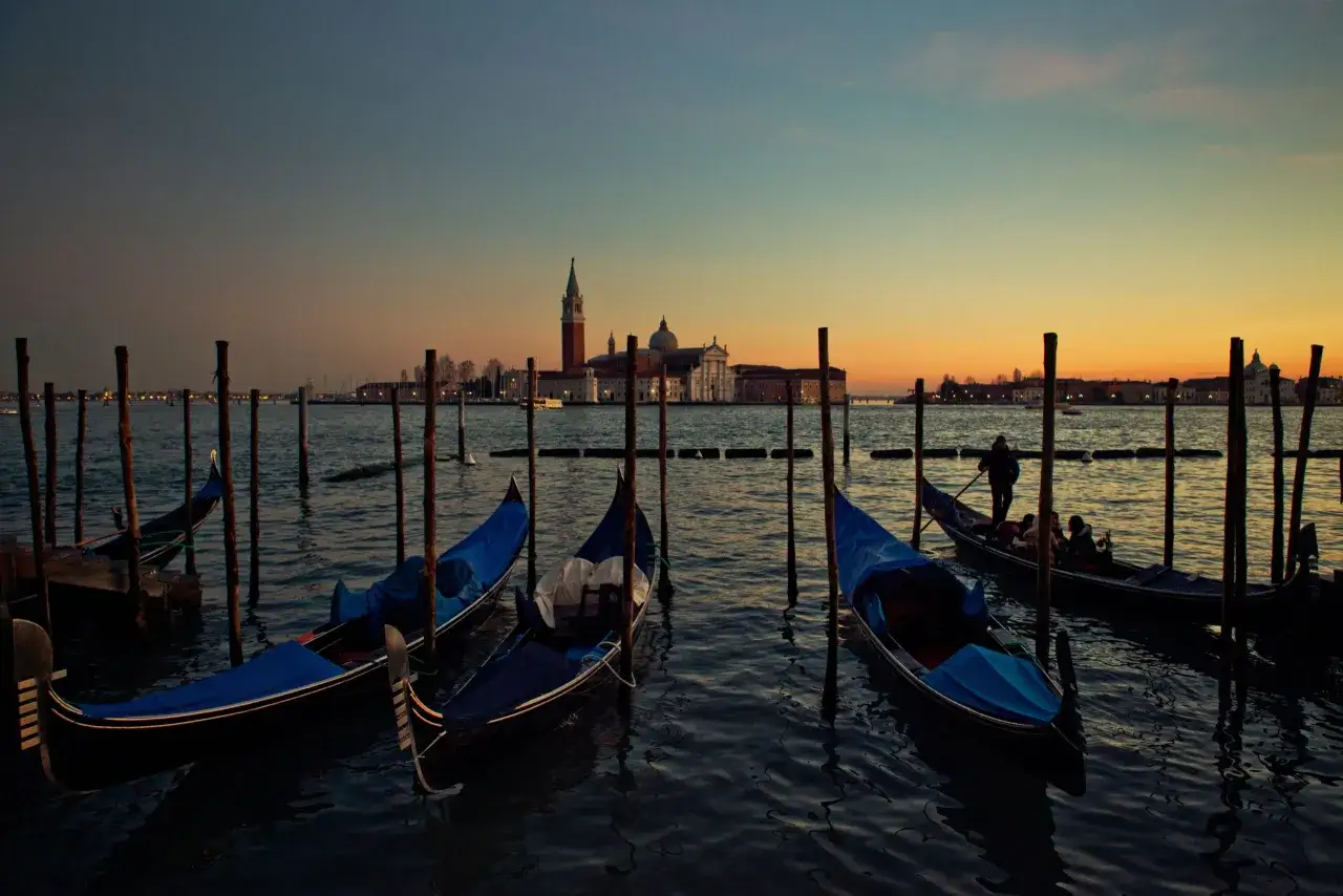 Gondole a Venezia al tramonto, con la Basilica di San Giorgio Maggiore sullo sfondo.
