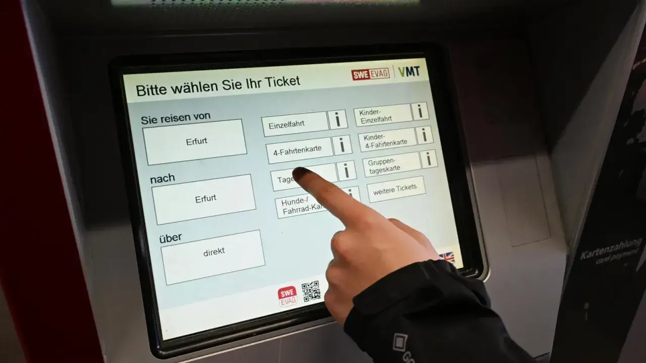 Ein Finger wählt am Ticketautomaten