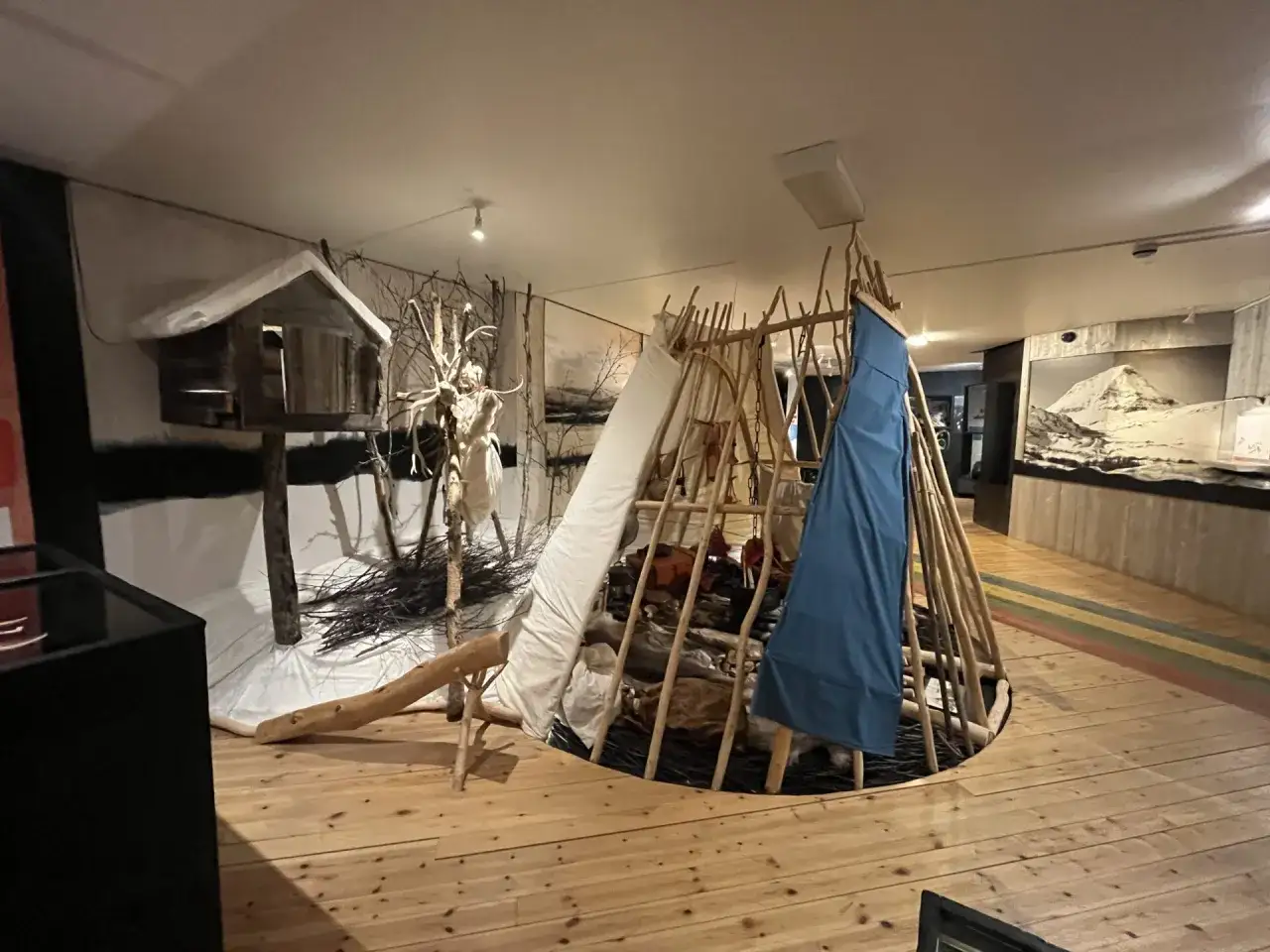 En utställning på samiskt museum i Kiruna visar en kåta med djurhudar och en fågelholk.