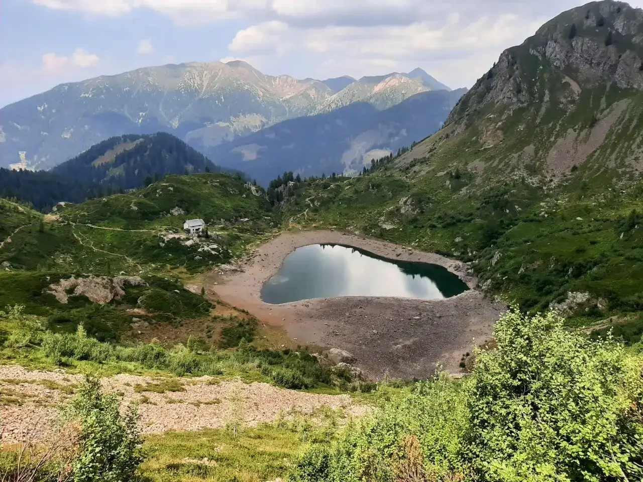 Sentiero per il lago di Erdemolo, con rifugio e montagne sullo sfondo.