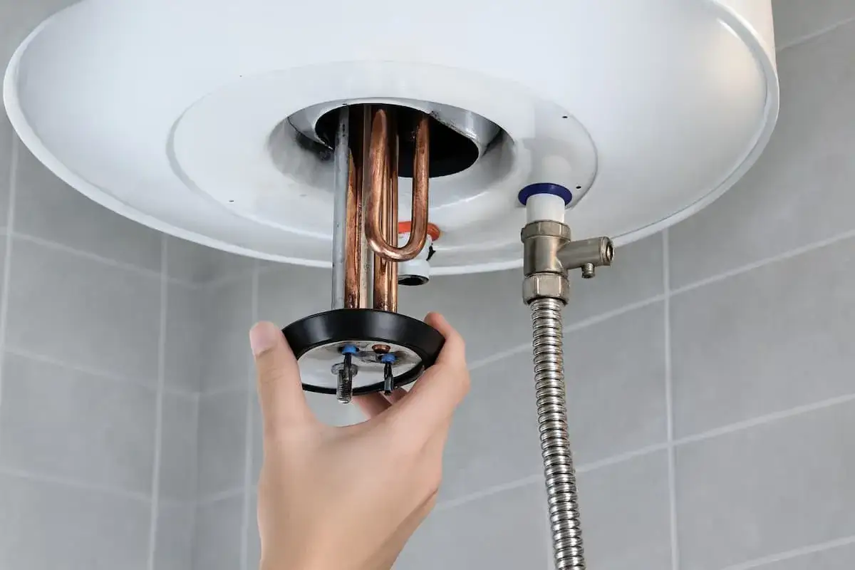 Mano manipulando el calentador de un termo el&eacute;ctrico. Averigua cuanto dura un termo el&eacute;ctrico y su mantenimiento.