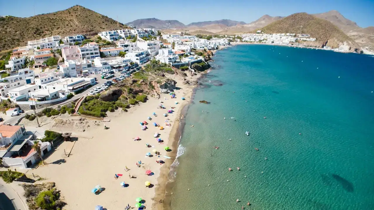 Vista aérea de la playa de San José, con casas blancas, arena dorada y aguas cristalinas. Ideal para saber qué ver en San José.