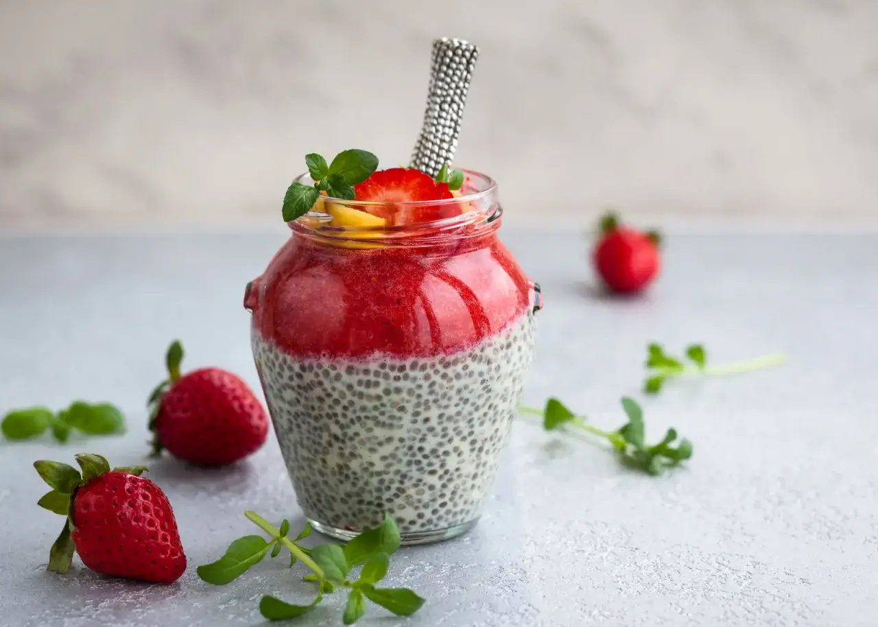 Pudding chia z truskawkami i mango w słoiku. Zastanawiasz się, dlaczego chia nie pęcznieje? Odpowiedź tkwi w odpowiednim nawodnieniu nasion.