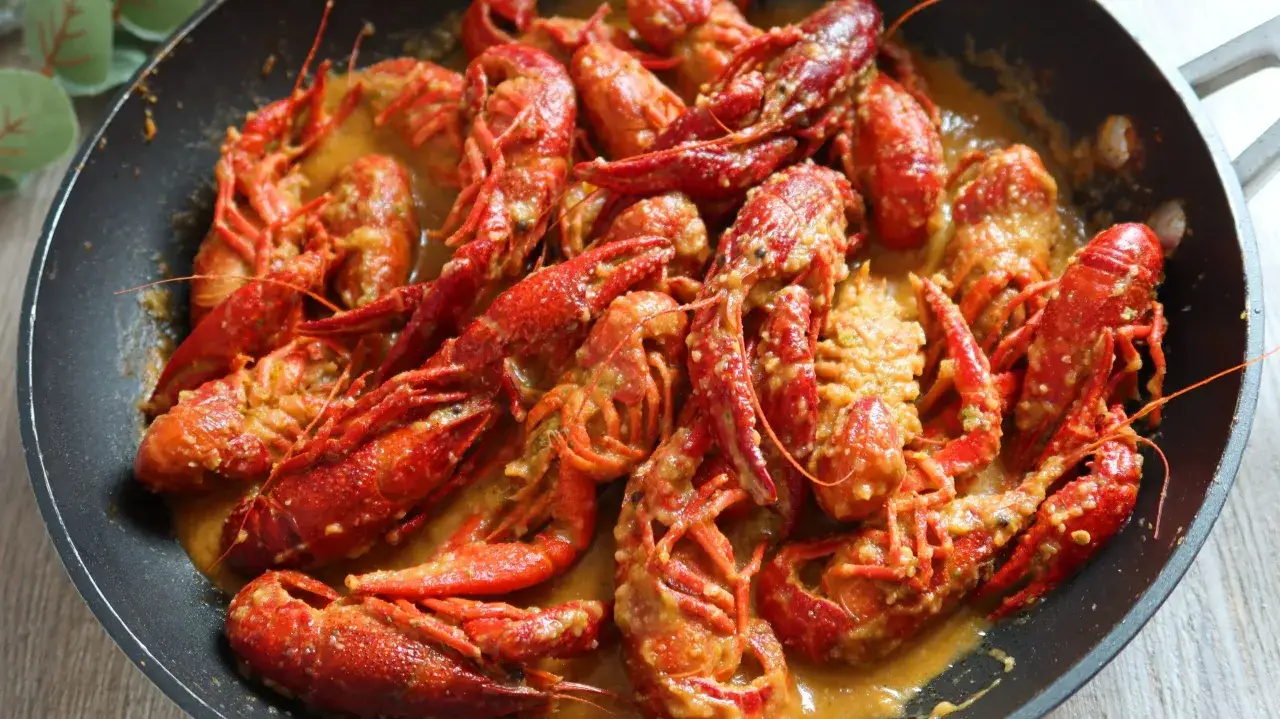 Un delicioso cangrejo de r&iacute;o en una sart&eacute;n, ba&ntilde;ado en una cremosa salsa. &iexcl;Un manjar listo para disfrutar!
