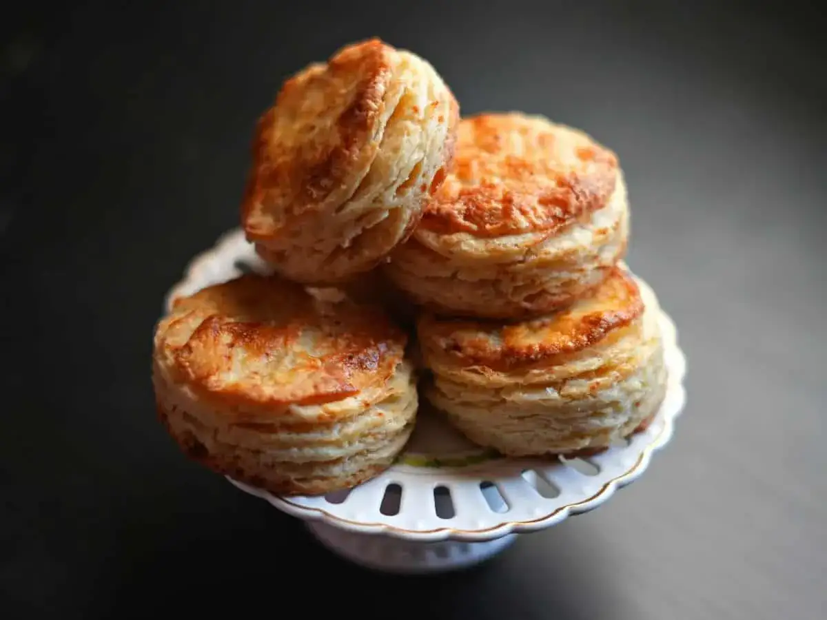 Gyllene, flagnande kex staplade på en vit bricka. Perfekt för ett filodeg recept.