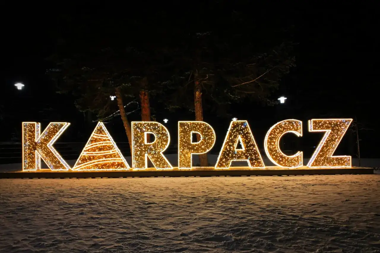 Świąteczna iluminacja Karpacz w zimowej scenerii. Litery tworzą napis