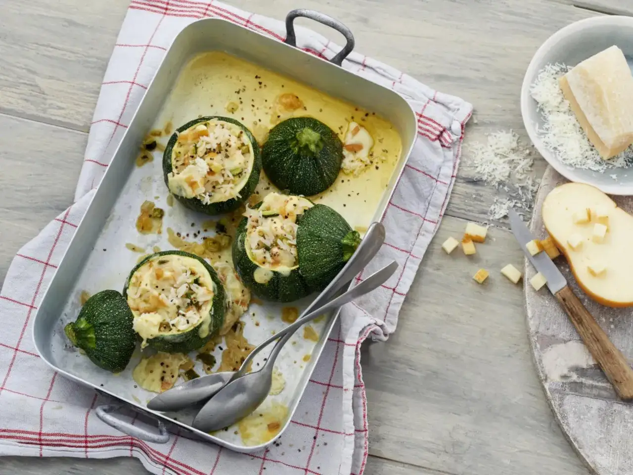 Gefüllte runde Zucchini mit Reis und Käse, ein köstliches runde zucchini rezept, bereit zum Servieren in einer Auflaufform.