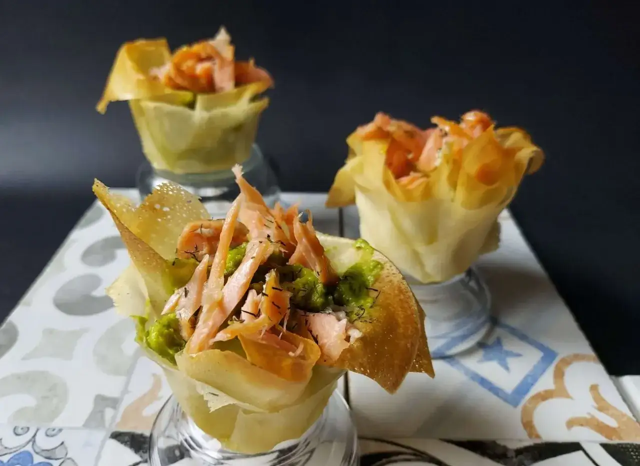 Deliciosos saquitos de pasta filo rellenos de salmón ahumado y aguacate, perfectos para un aperitivo elegante.