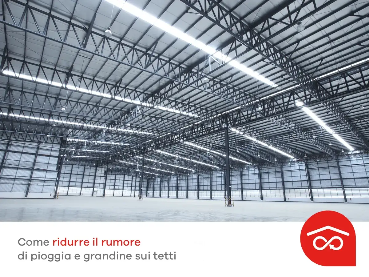 Interno di un capannone con tetto metallico e struttura a vista. L'immagine suggerisce come un tetto coibentato possa ridurre il rumore.