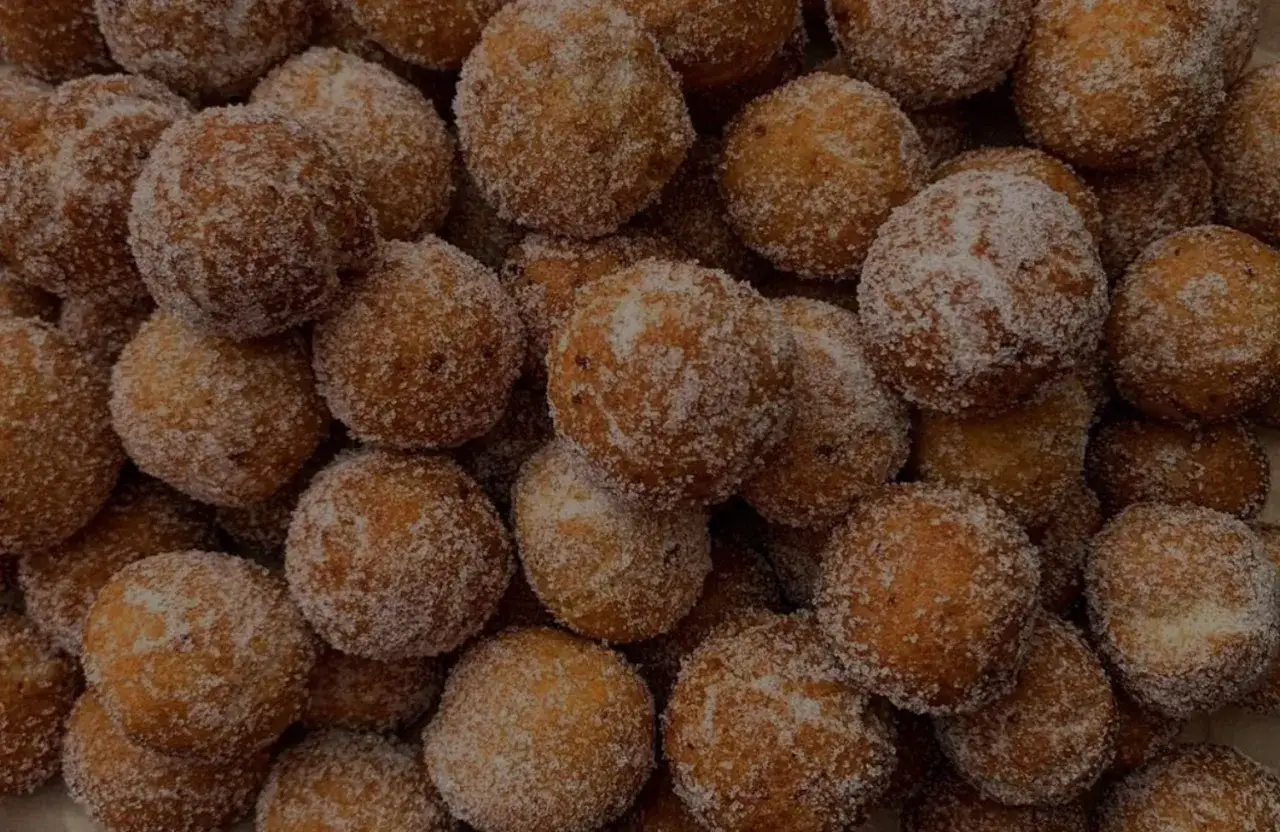 Un mucchio di dolci tipici di Tropea, piccole palline fritte e cosparse di zucchero, invitano a un assaggio goloso.