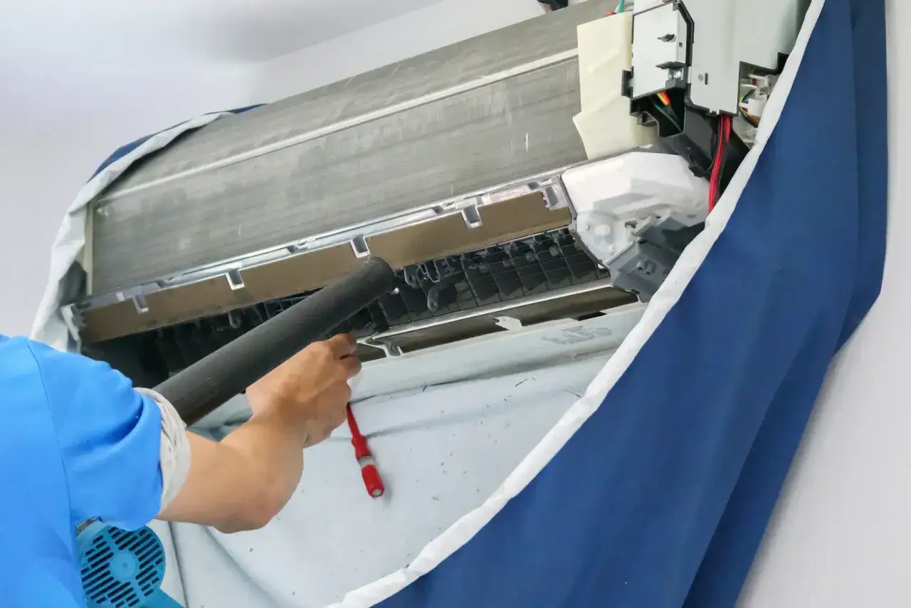 Técnico limpia el aire acondicionado. El coil dry es esencial para evitar la humedad y el moho, manteniendo el equipo funcionando óptimamente.