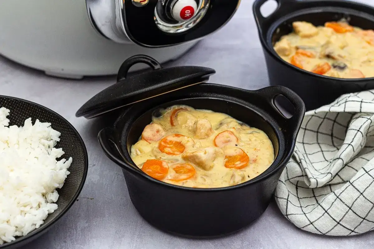 Blanquette de poulet Cookeo servie dans des cocottes individuelles, accompagnée de riz blanc. Un plat crémeux aux carottes et champignons.