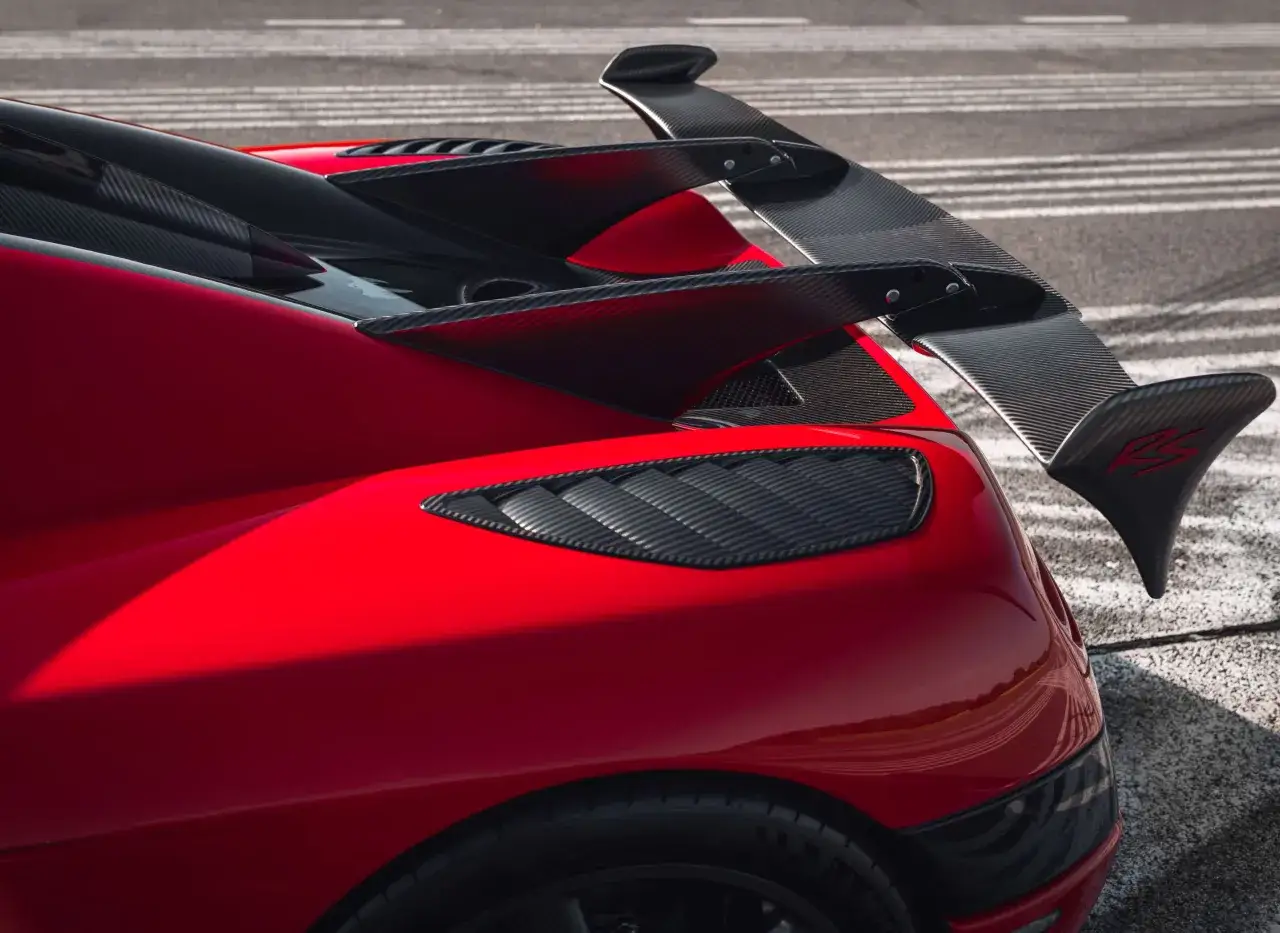 Der rote Koenigsegg Agera RS mit seinem markanten Carbon-Heckfl&uuml;gel und den Lufteinl&auml;ssen auf der Stra&szlig;e.