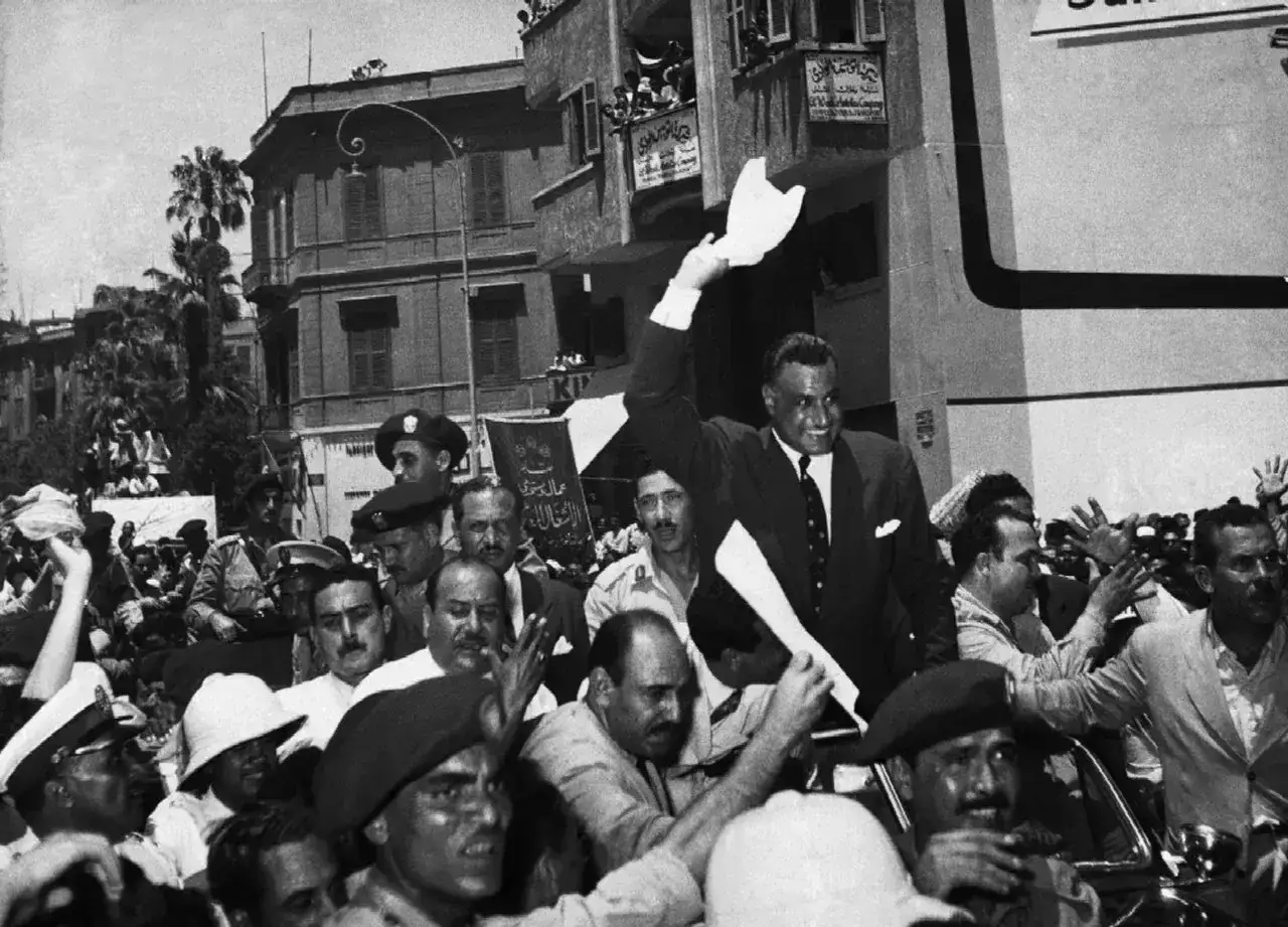 Gamal Abdel Nasser, 2. prezydent Egiptu, pozdrawia tłum z samochodu.