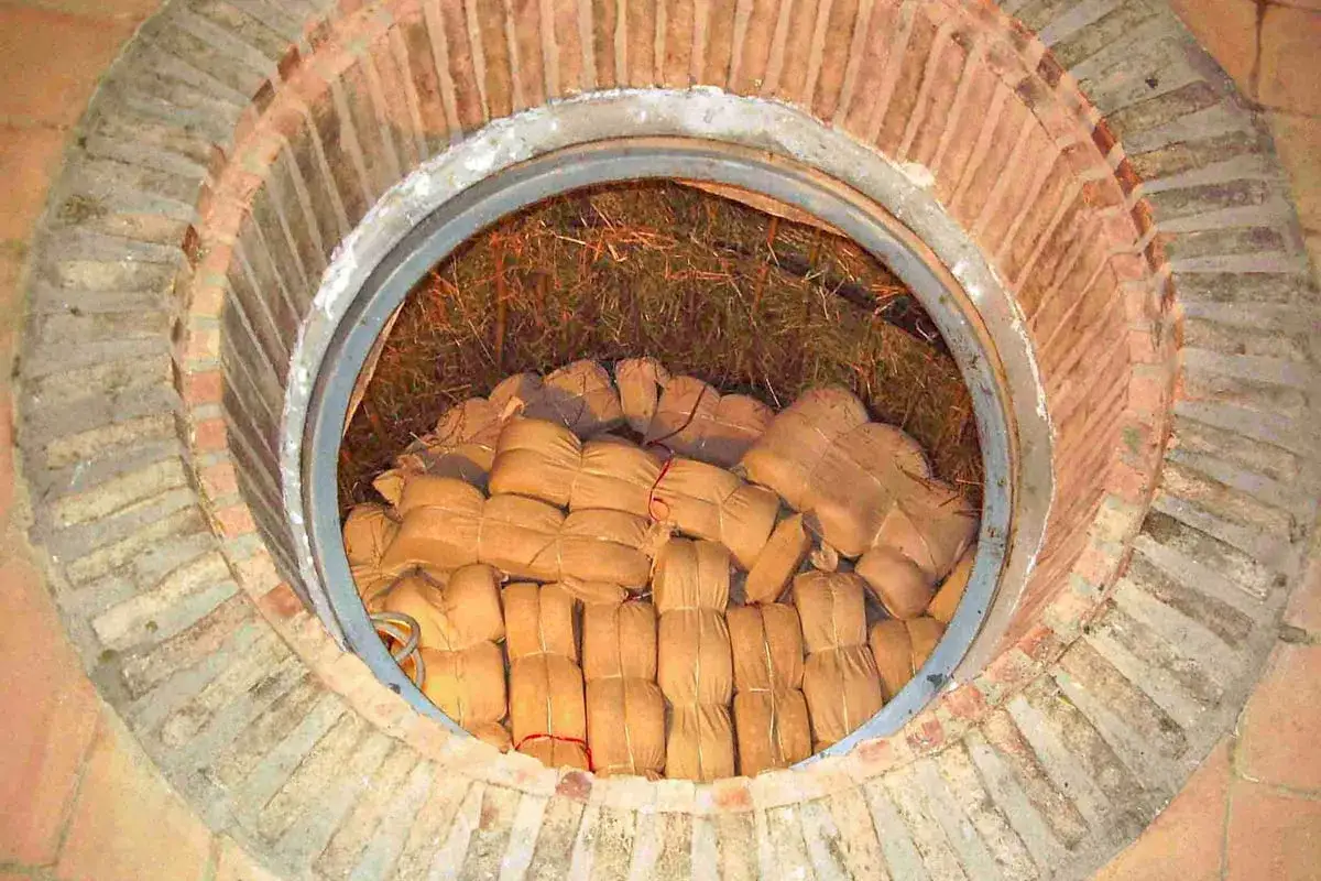 Formaggio di fossa in maturazione, avvolto in teli e riposto in una fossa di tufo.